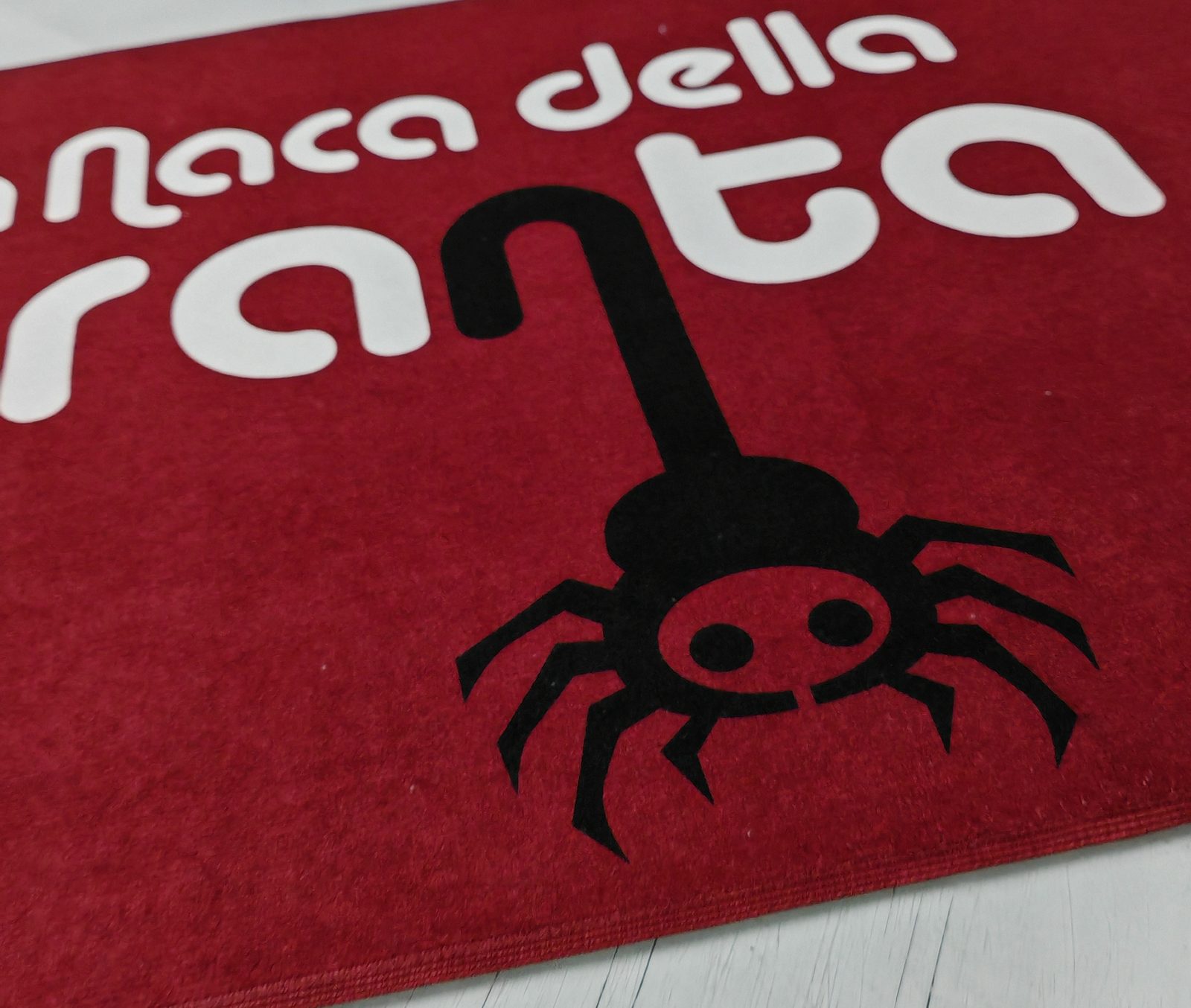 Dettaglio dell&rsquo;asciugamano bordeaux personalizzato con il logo La Naca della Taranta mediante sublimazione, B&B di Galatina in provincia di Lecce