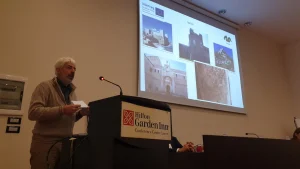 Relatore al leggio con le slide proiettate durante un convegno a Lecce