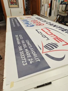 Striscione in rete microforata per cantiere, steso sul banco del laboratorio